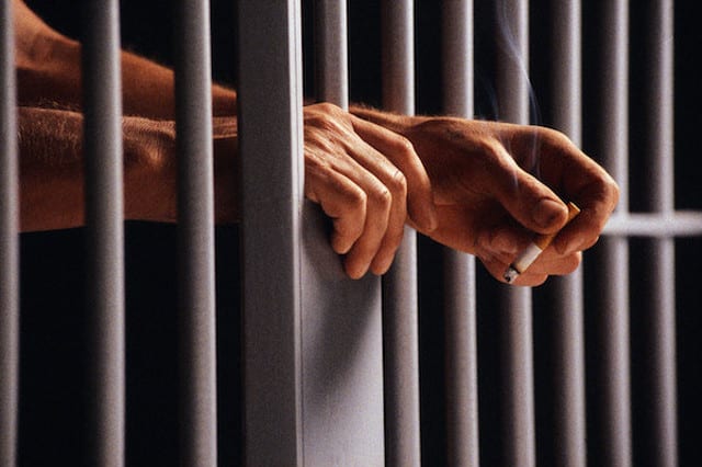 State College - Prisoner Holding Cigarette Between Bars