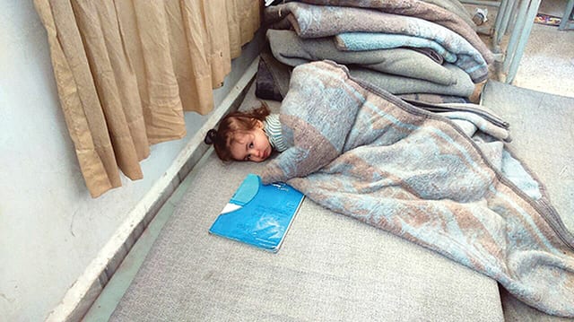 State College - A girl tries to take a nap next to the stack of blankets at a we