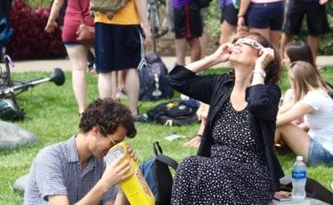 Kyle Posey views a projected image of the partial eclipse through a pinhole camera while Lisa Posey uses special safety glasses at the Arboretum on the afternoon of Aug. 21, 2017