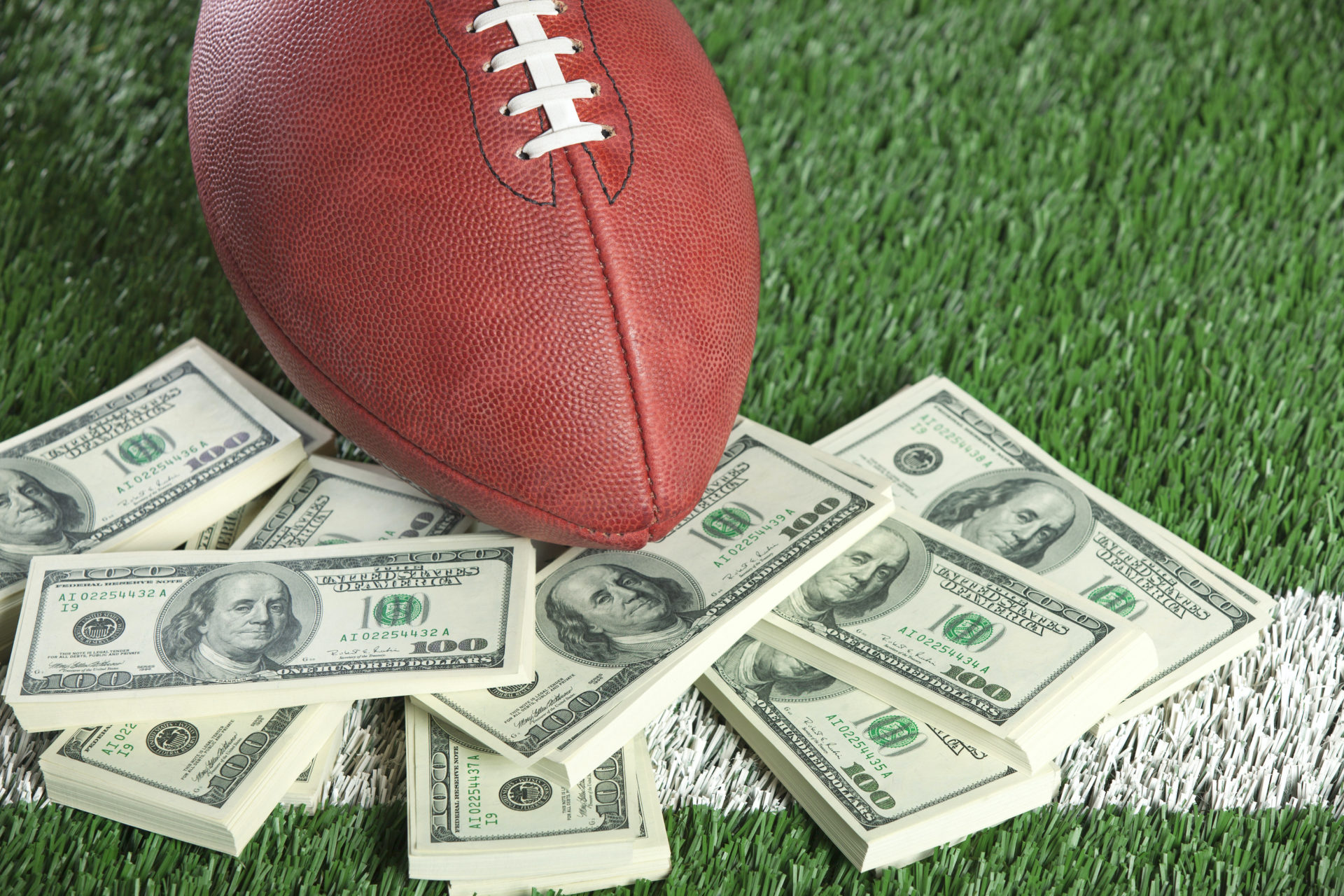 football on field with a pile of money