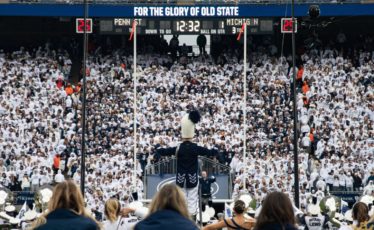 Penn State Blue Band drum major leads the band in front of the student section at Penn State football's Beaver Stadium