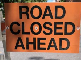 Orange sign with black letters reading 