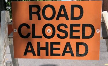 Orange sign with black letters reading 