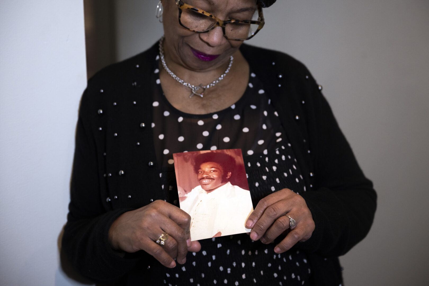 Mary Buffaloe holds a photo of her brother Raymond Michael Caliman at her home in Philadelphia on Wednesday, Nov. 15, 2023. The photo shows Raymond in 1980 on Mary’s wedding day.