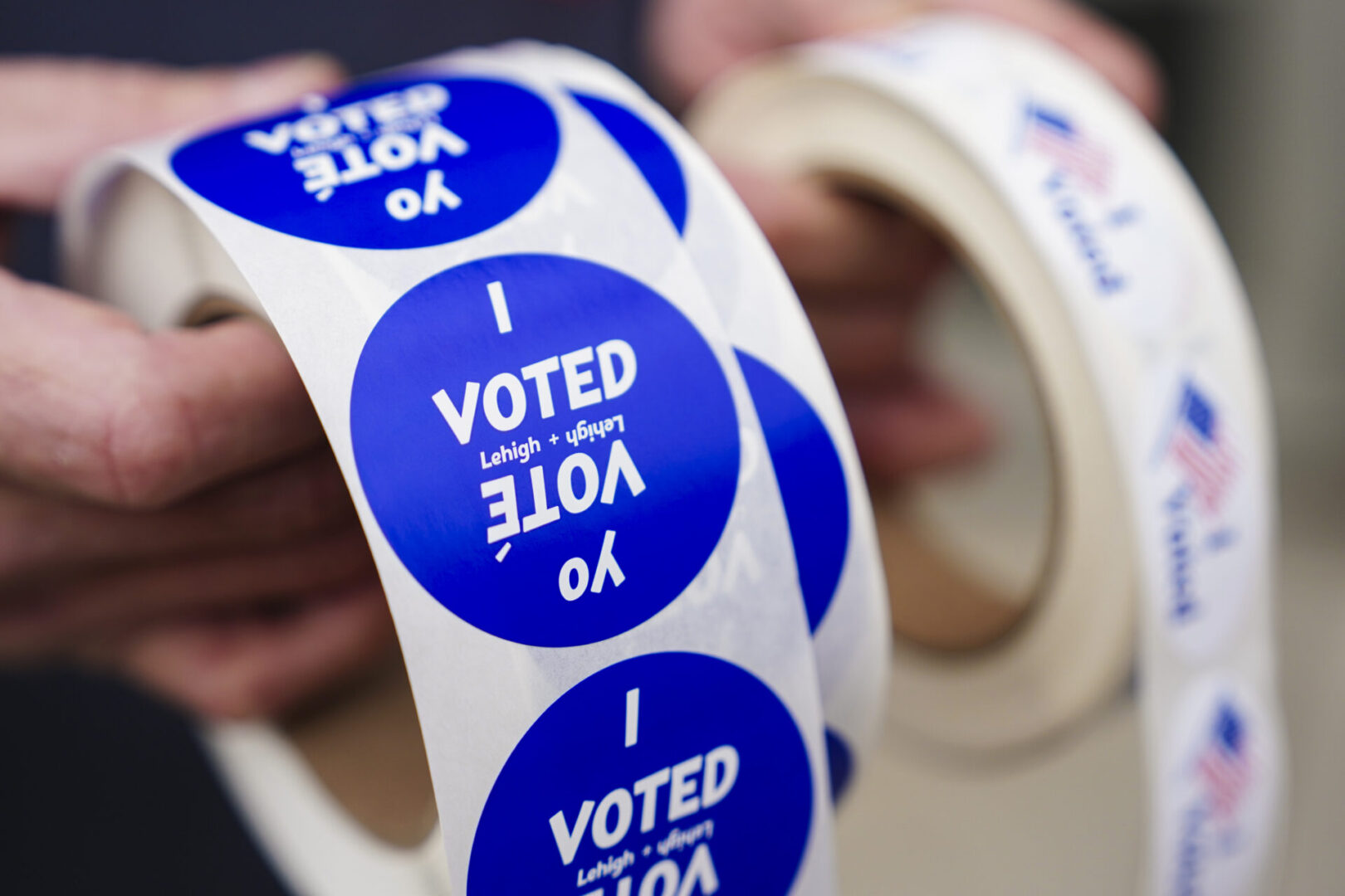 A poll worker holds voting stickers for community members Nov. 7, 2023, at Central Elementary School in Allentown, Lehigh County, Pennsylvania. Photo by Matt Smith | For Spotlight PA