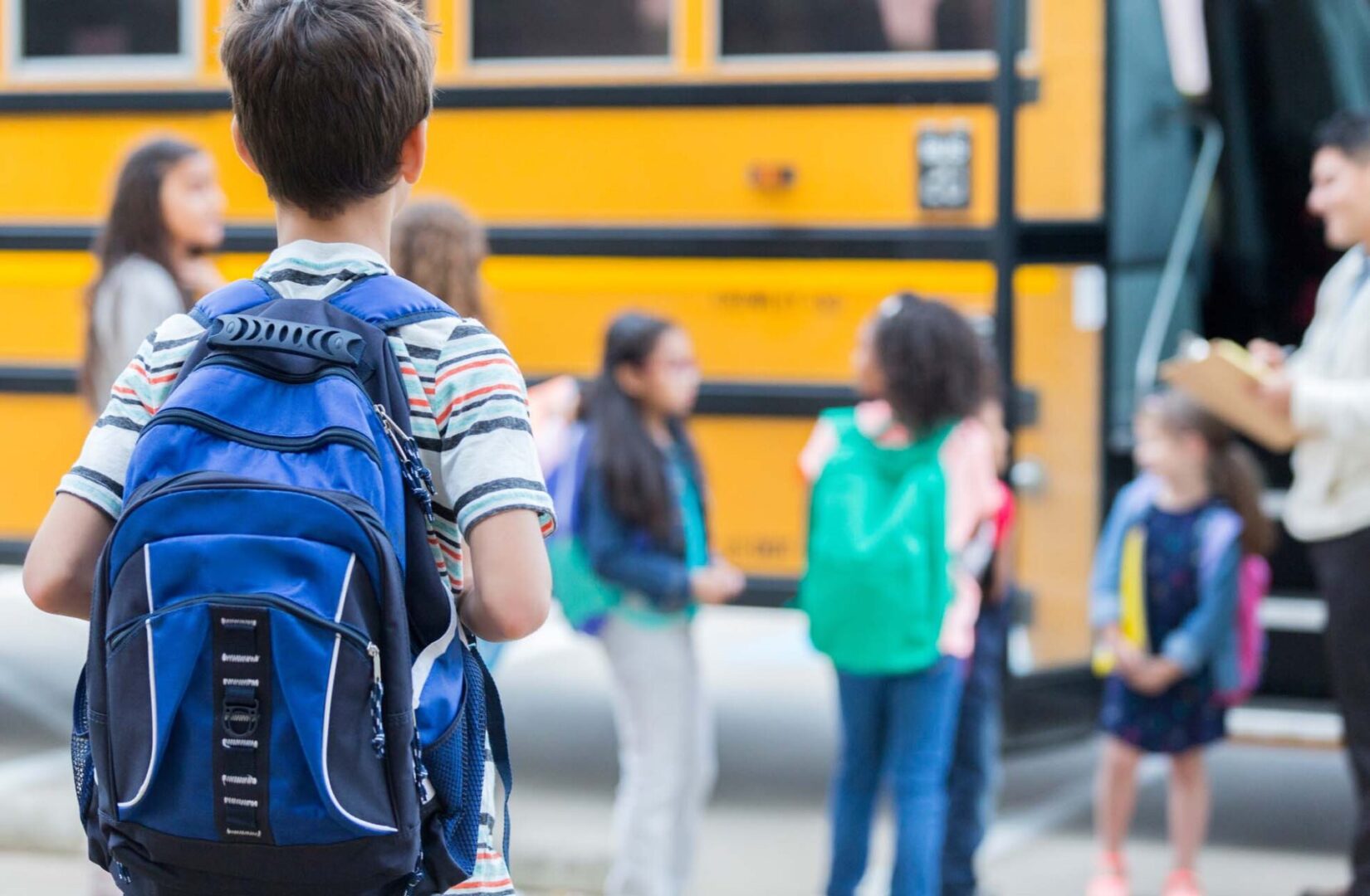 State College - Young boy waits to load school bus