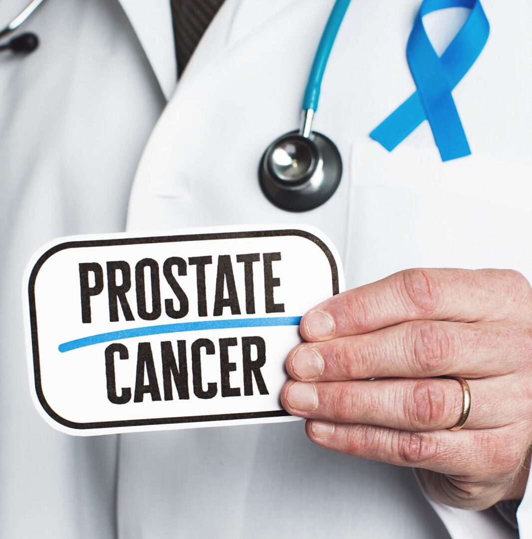 State College - Doctor with stethoscope in white lab coat holding sign reading prostate cancer