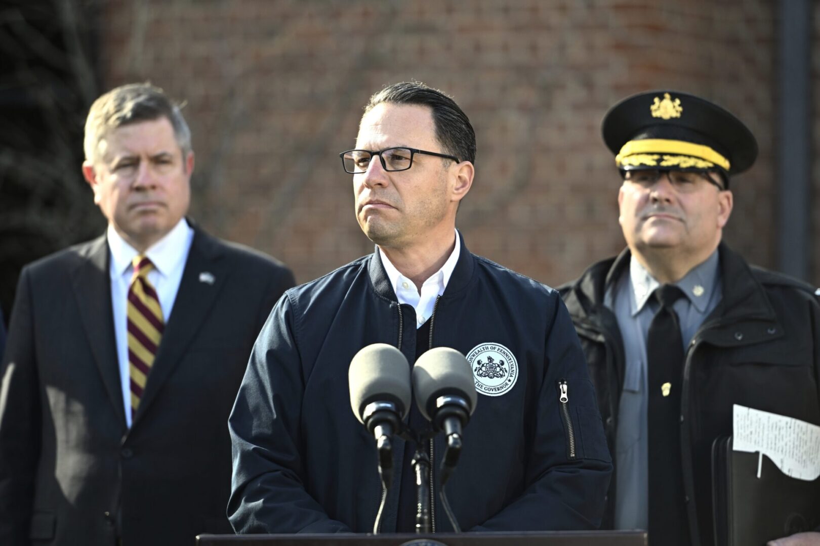 Gov. Josh Shapiro (center) is flanked by Dauphin County DA Fran Chardo (left) and Colonel Christopher Paris of the State Police