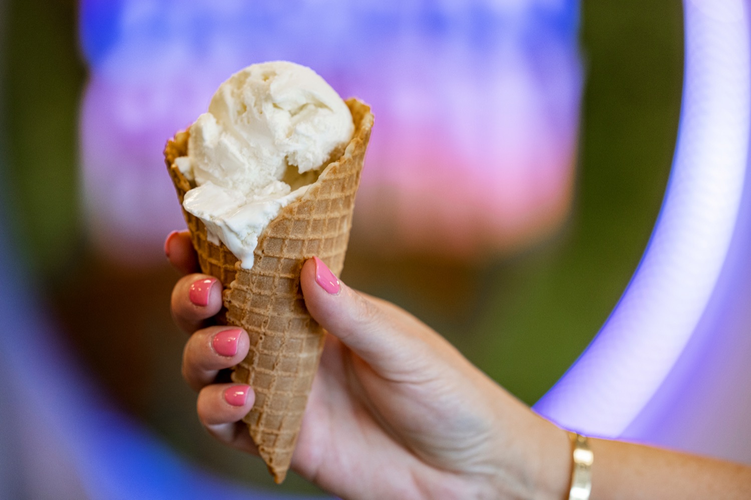 a hand holds an ice cream cone