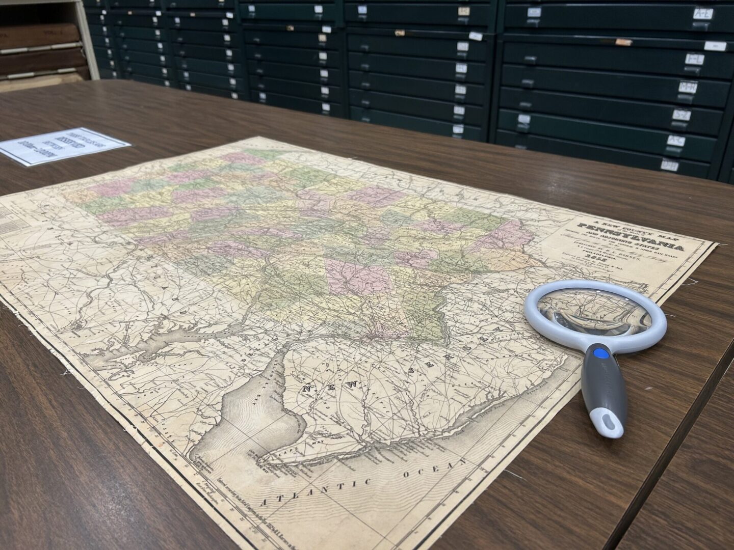 A map of Pennsylvania and a magnifying glass.
